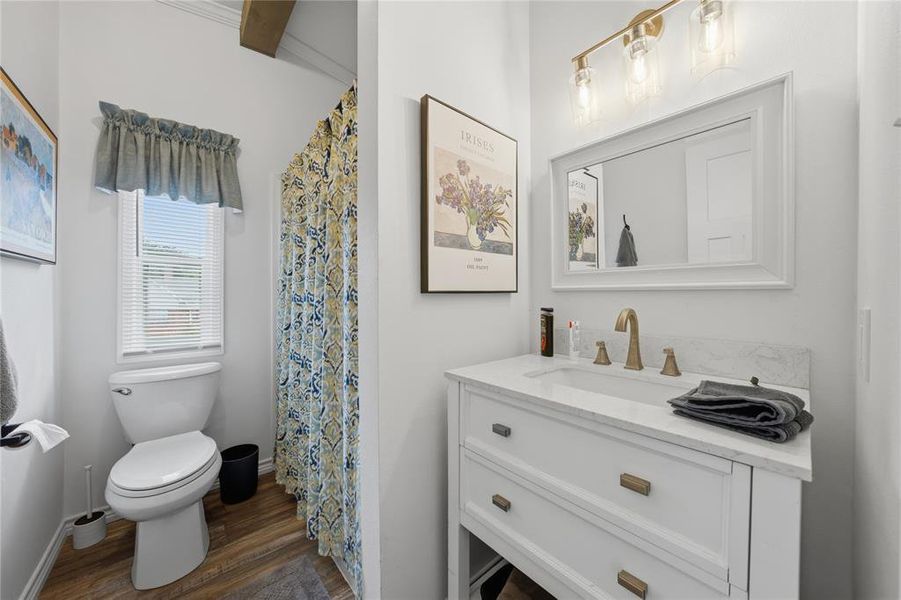 Bathroom featuring a white vanity with a light-toned countertop, a framed mirror, and a three-light vanity fixture