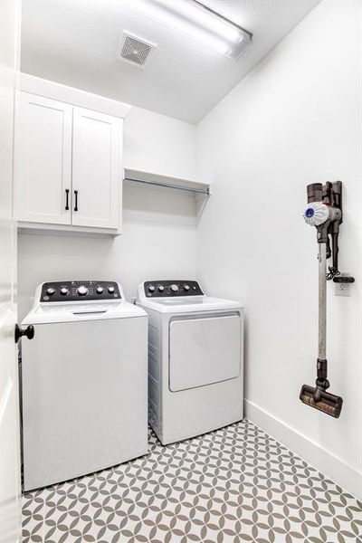 Laundry room with adorable, tile flooring.