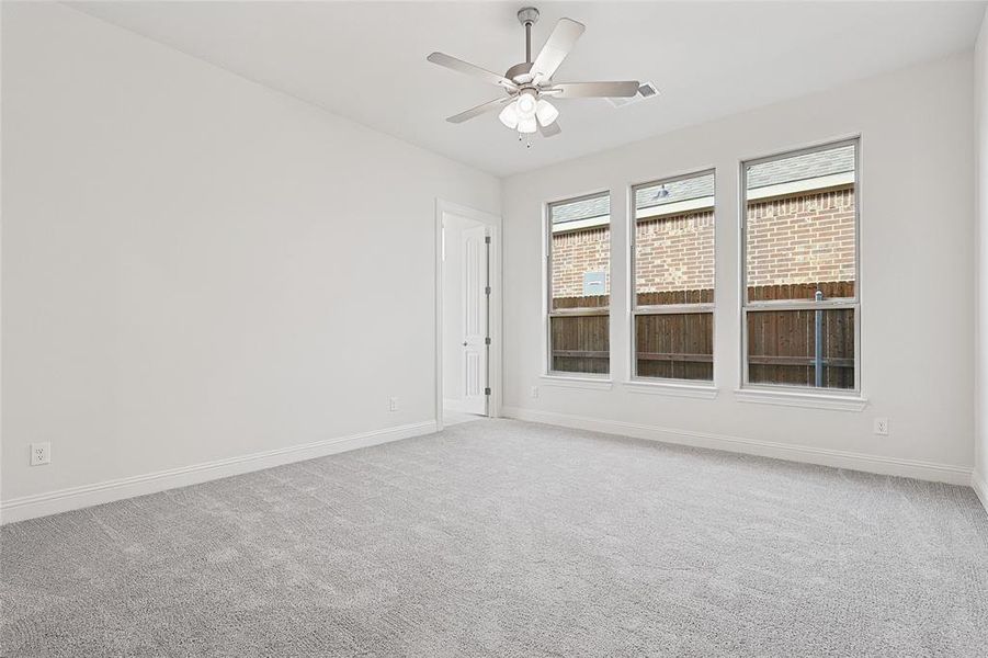 Carpeted spare room featuring ceiling fan