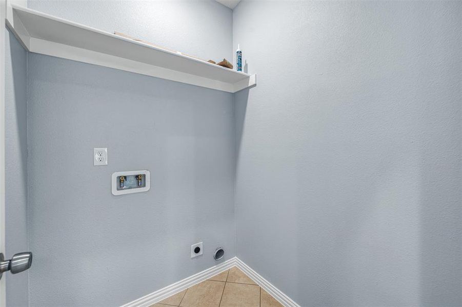 Washroom with washer hookup, electric dryer hookup, and light tile patterned flooring