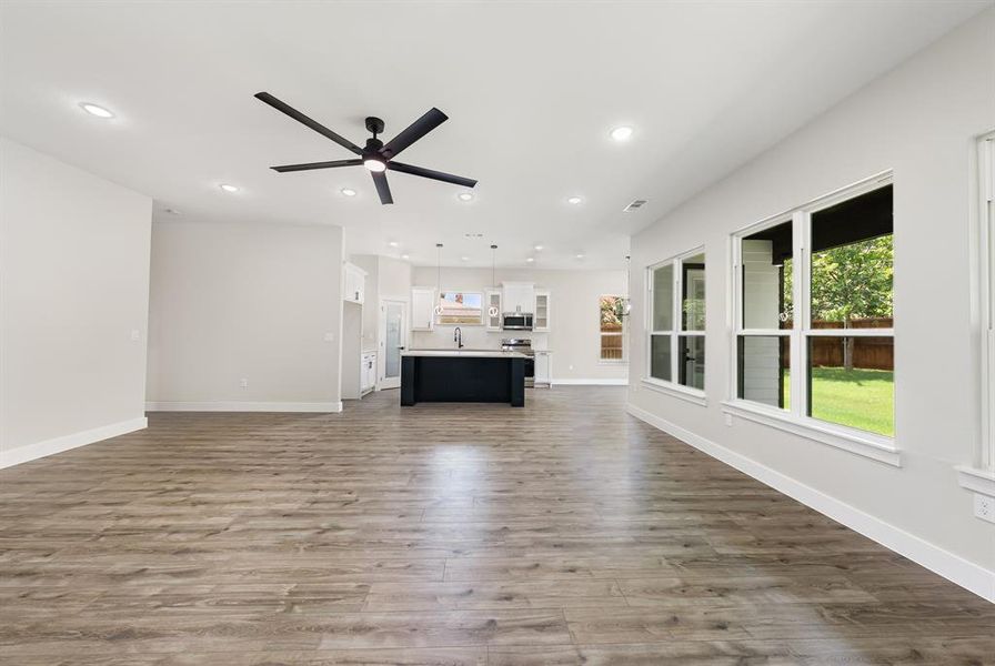 Unfurnished living room featuring dark wood finished floors, recessed lighting, and a ceiling fan Unfurnished living room featuring dark wood finished floors, recessed lighting, and a ceiling fan