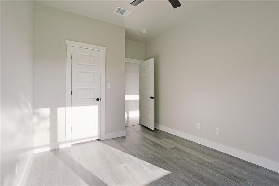 Unfurnished bedroom with wood-type flooring and ceiling fan