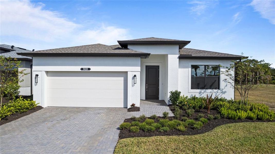 Front exterior of a new home in Woodland Preserve, Parrish, FL, highlighting curb appeal (Image 2). Front exterior of a new home in Woodland Preserve, Parrish, FL, highlighting curb appeal (Image 2).