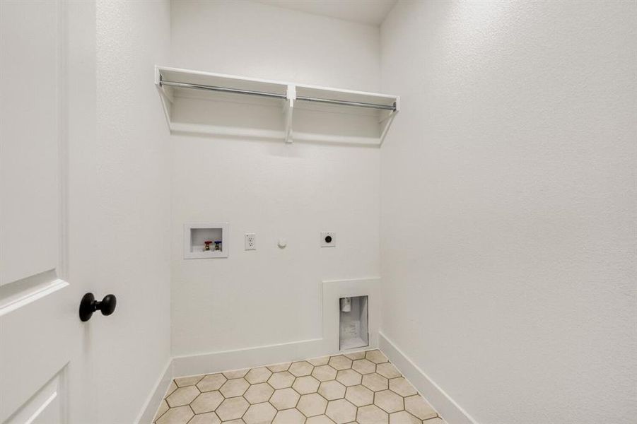 Laundry room with hookup for a gas dryer, light tile patterned floors, electric dryer hookup, and hookup for a washing machine Laundry room with hookup for a gas dryer, light tile patterned floors, electric dryer hookup, and hookup for a washing machine