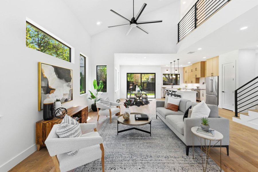 Living room with high vaulted ceiling, recessed lighting, light wood-type a ceiling fan opens to kitchen and dining for ease to entertain