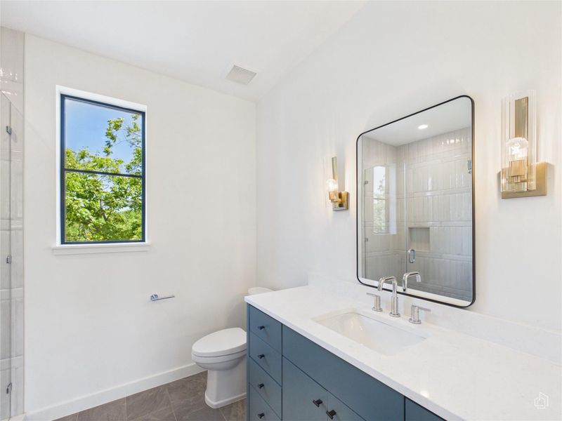 Clean lines and timeless tilework define this elegant secondary bath space.