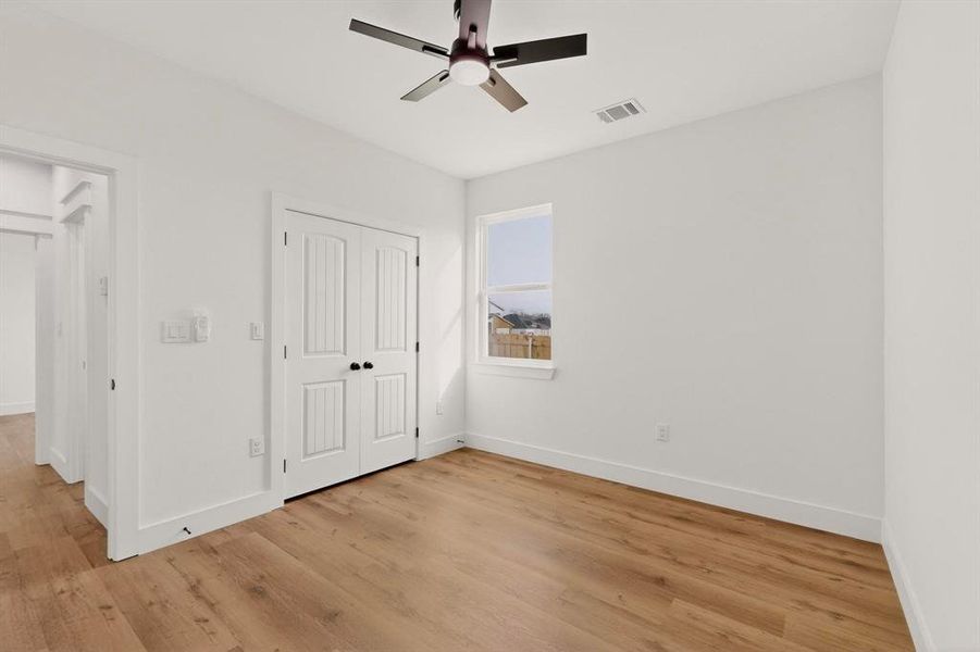 Unfurnished bedroom featuring light wood-style flooring, a closet, and a ceiling fan Unfurnished bedroom featuring light wood-style flooring, a closet, and a ceiling fan