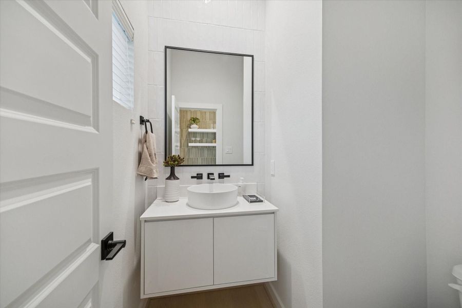 Modern powder bath featuring a floating vanity, vessel sink, and sleek matte black fixtures. Clean tilework and layered textures give this small space a refined, contemporary finish. Modern powder bath featuring a floating vanity, vessel sink, and sleek matte black fixtures. Clean tilework and layered textures give this small space a refined, contemporary finish.