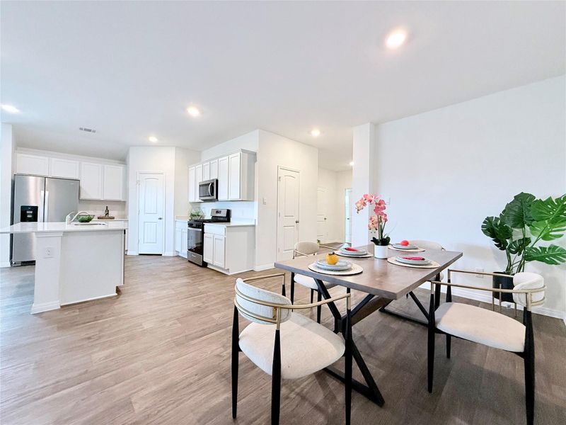 Dining room with light wood-type flooring and recessed lighting Dining room with light wood-type flooring and recessed lighting
