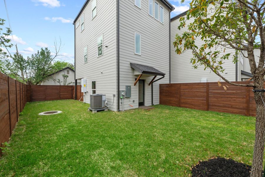 A fully enclosed lawn offers private outdoor space behind the multi-story home.