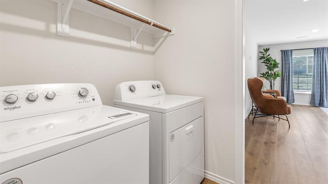 Dedicated laundry area featuring a white top-load washing machine and white electric dryer