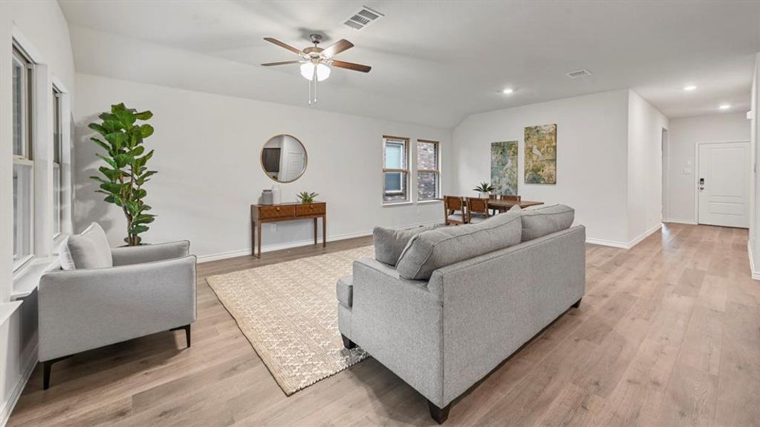 Living room with light wood-style flooring, a ceiling fan, recessed lighting, and vaulted ceiling