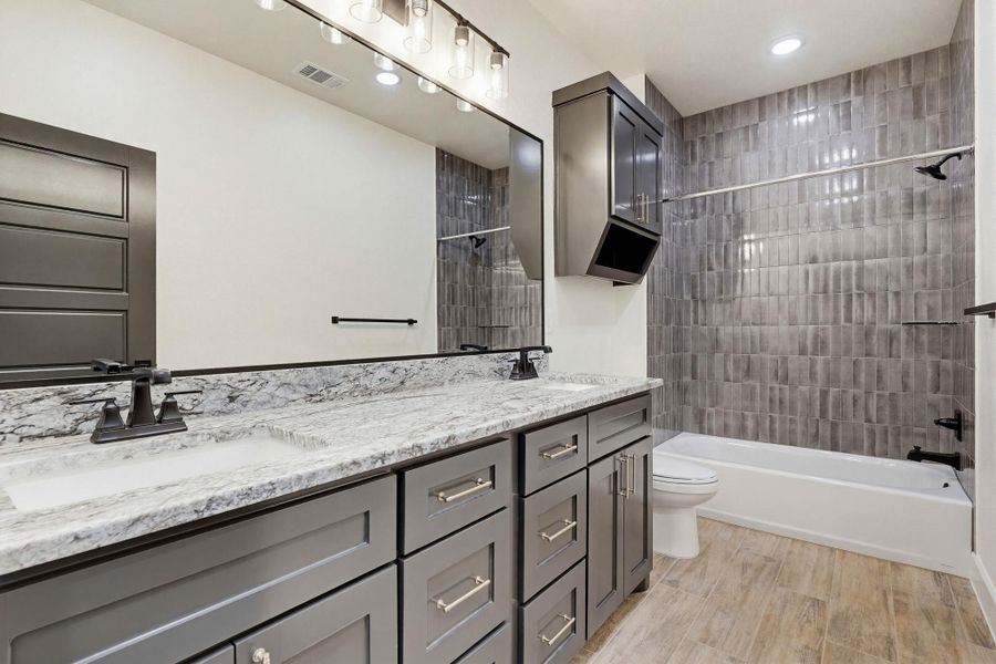 Dual vanities with granite counters provide ample space in this well-appointed bath. Dual vanities with granite counters provide ample space in this well-appointed bath.
