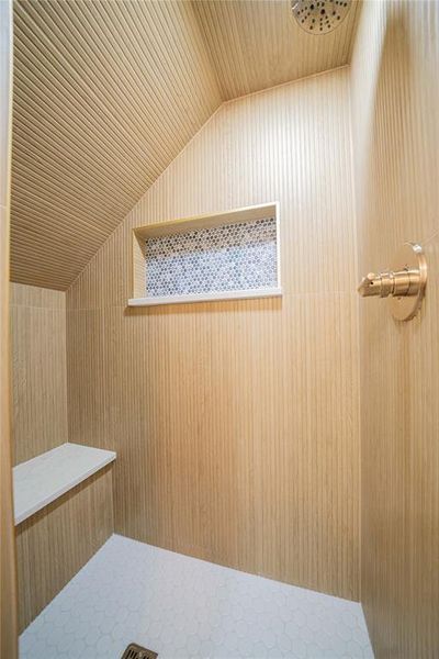 Bathroom view of a tile shower, wooden ceiling, and wooden walls Bathroom view of a tile shower, wooden ceiling, and wooden walls