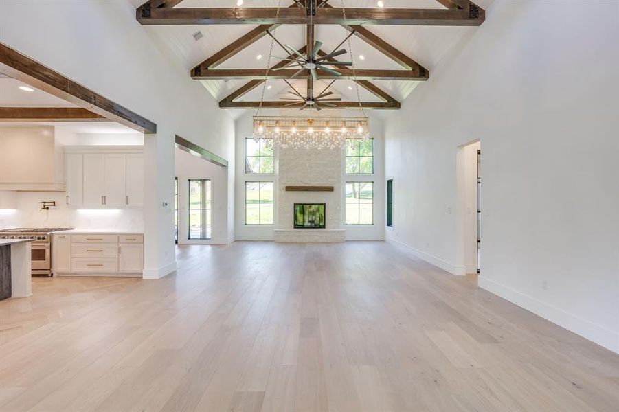 Unfurnished living room featuring light wood-style flooring, a fireplace, and a ceiling fan
