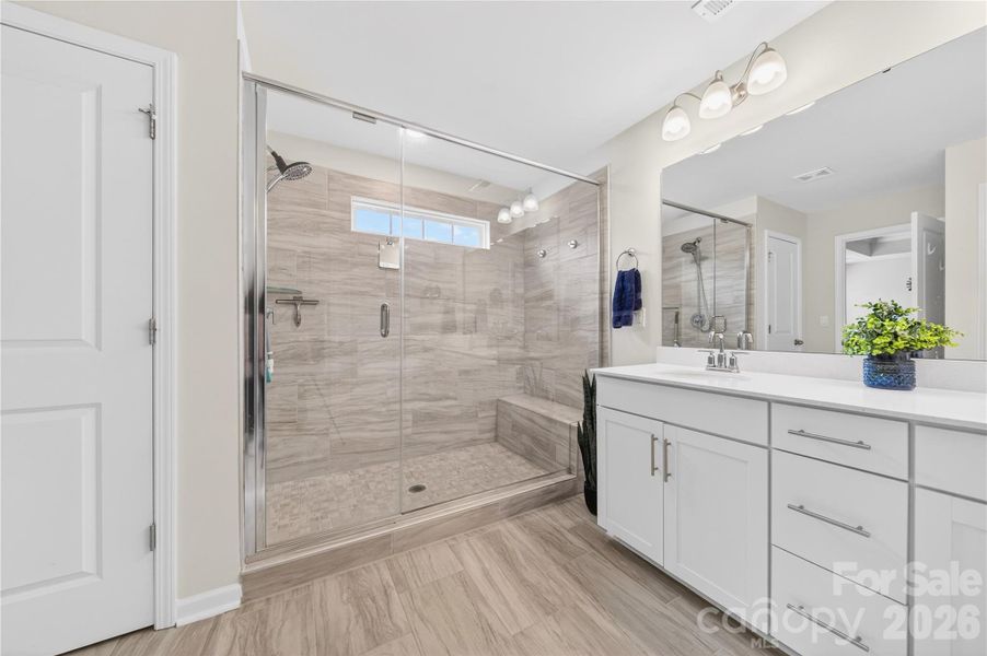 The primary ensuite features a oversized shower with light streaming through the transom window, double bowl sink, private water closet, linen closet and large WIC.
