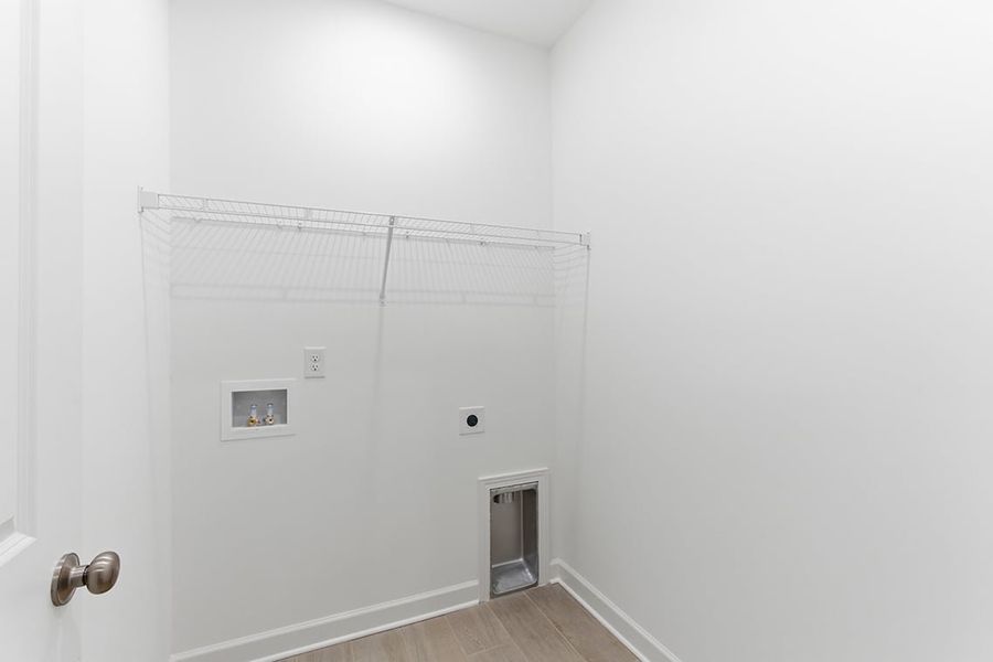 A white room with a door and a white wall.