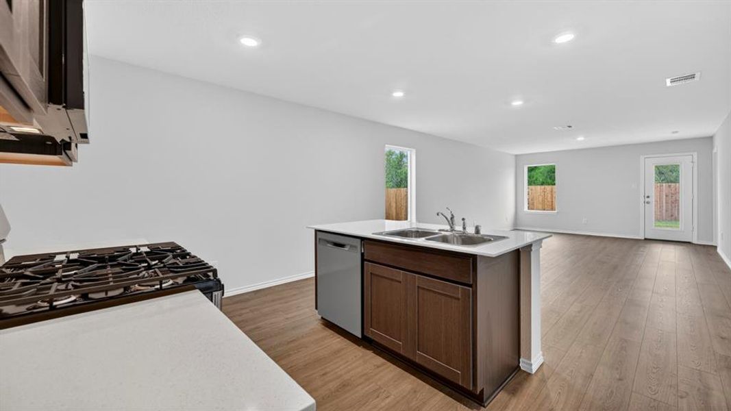 Open-concept kitchen and living area featuring wood-finish flooring