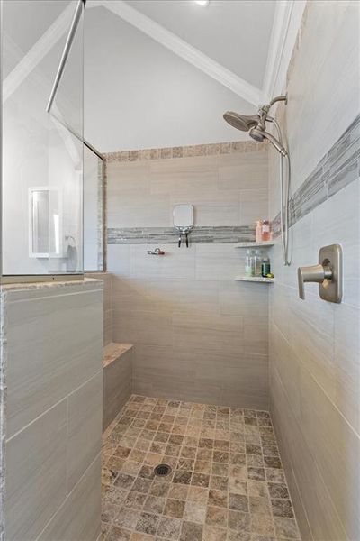 Bathroom featuring ornamental molding and a tile shower