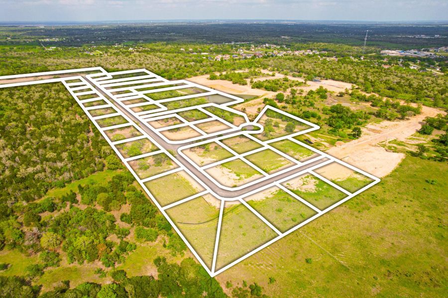 Visualize this development's layout with defined lots and new roads against a natural landscape.
