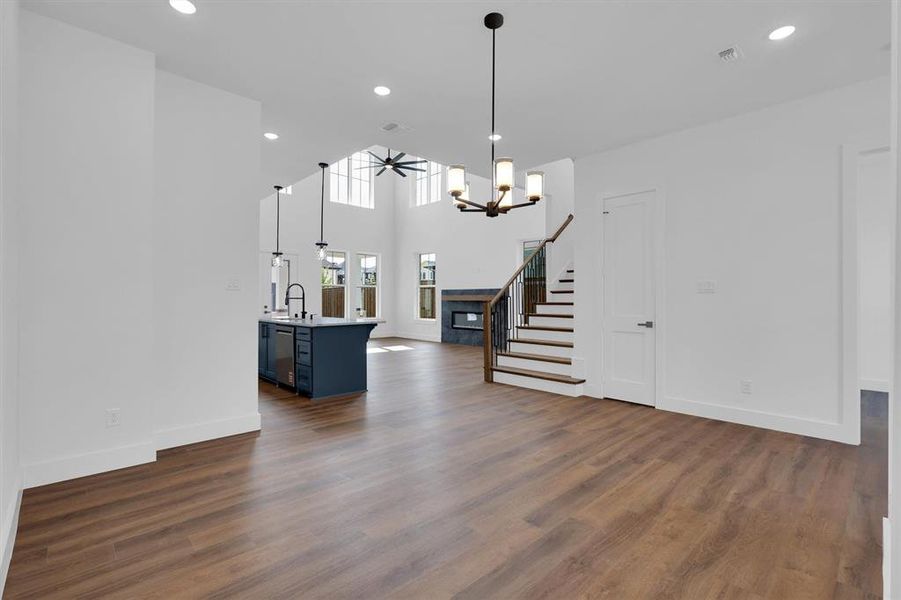 Dining room with stairs, dark wood-type flooring, a chandelier, and recessed lighting Dining room with stairs, dark wood-type flooring, a chandelier, and recessed lighting
