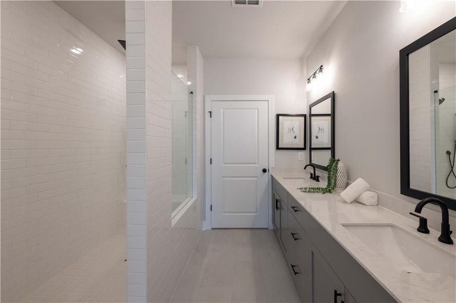 The primary bathroom features double vanity and an extra large walk in shower. *Please note that pictures shown are of the Jacobsen II floorplan but they are not of the actual home listed.