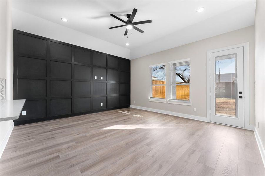 Empty room with ceiling fan and light wood-type flooring