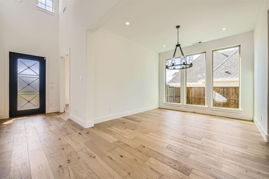 Entrance foyer with light hardwood / wood-style flooring and an inviting chandelier