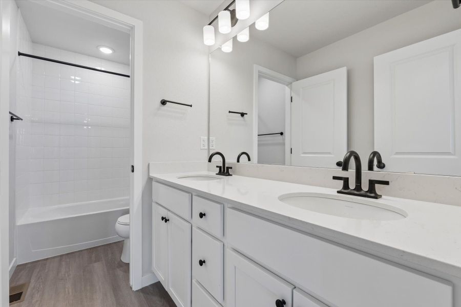 A bathroom with white cabinets.