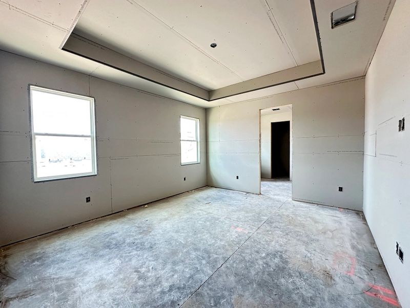 Primary bedroom featuring a tray ceiling - under construction