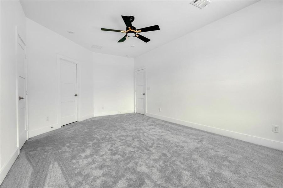 Carpeted spare room with ceiling fan