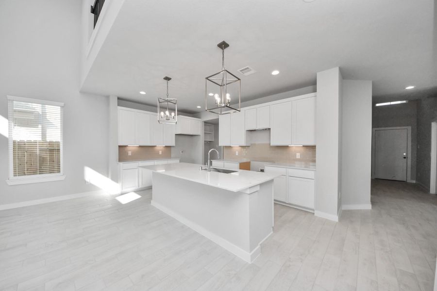 Step into a dream realized with this generously spacious kitchen! A massive granite island takes center stage, complemented by high ceilings and soft-close cabinets. The granite countertops, stainless steel appliances, sleek tile backsplash, and recessed lighting complete the elegant design. Sample photo of completed home with similar floor plan. Actual colors and selections may vary. Step into a dream realized with this generously spacious kitchen! A massive granite island takes center stage, complemented by high ceilings and soft-close cabinets. The granite countertops, stainless steel appliances, sleek tile backsplash, and recessed lighting complete the elegant design. Sample photo of completed home with similar floor plan. Actual colors and selections may vary.