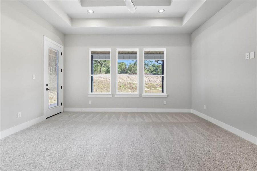 Unfurnished room with a raised ceiling, light colored carpet, and recessed lighting Unfurnished room with a raised ceiling, light colored carpet, and recessed lighting
