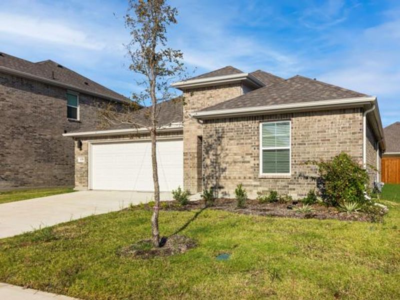 View of front of home with a front yard and a garage