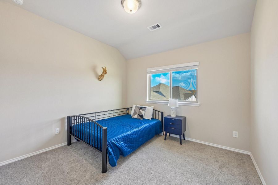 Bright and cozy bedroom featuring a window with a scenic view, a comfortable daybed, and a stylish nightstand.
