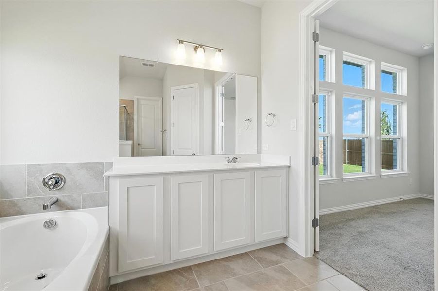 Bathroom featuring a garden tub, vanity, tile patterned floors, and a shower with door Bathroom featuring a garden tub, vanity, tile patterned floors, and a shower with door