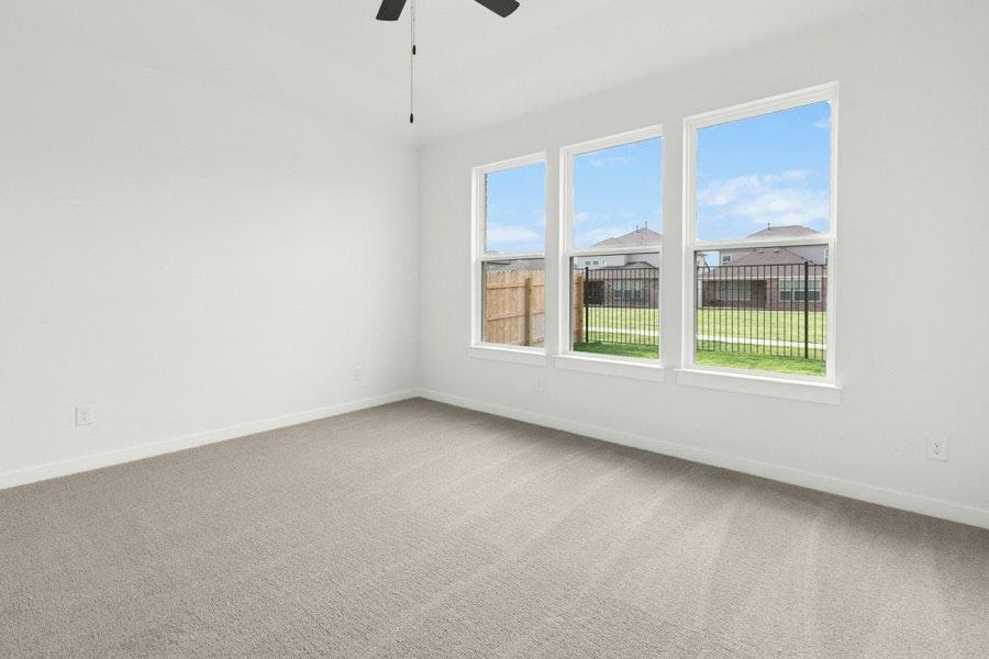 Unfurnished room with light colored carpet and a ceiling fan