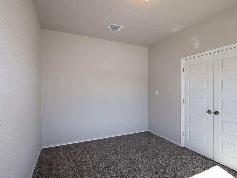 Empty room featuring dark colored carpet and baseboards