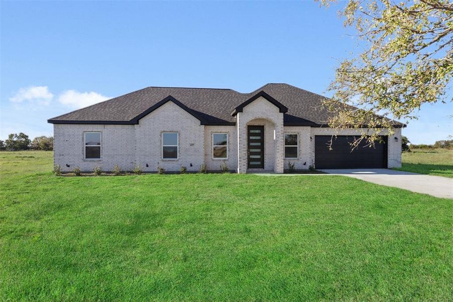 View of front of property with a front yard and a garage