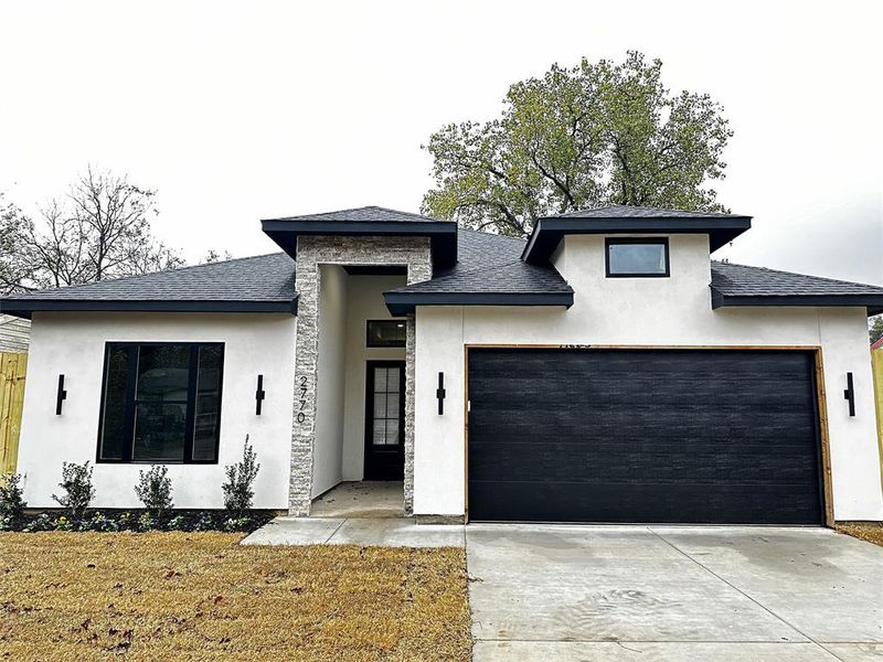 View of front of home featuring stucco siding, concrete driveway, and a shingled roof View of front of home featuring stucco siding, concrete driveway, and a shingled roof