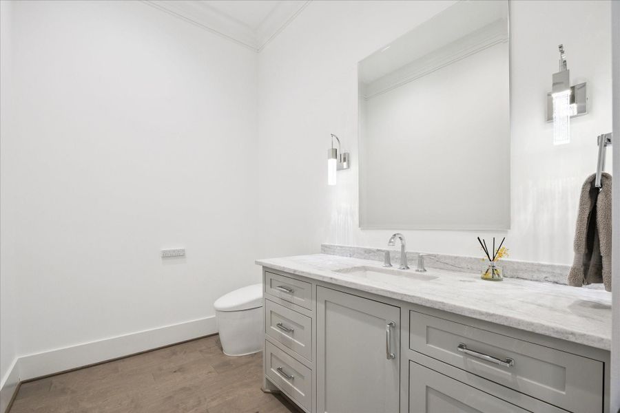 Downstairs powder bath with one of three upgraded high-end Toto toilets in the home upgraded by the Sellers. Extra storage and counter space, large mirror flanked by sconces and tasteful hardware throughout. Downstairs powder bath with one of three upgraded high-end Toto toilets in the home upgraded by the Sellers. Extra storage and counter space, large mirror flanked by sconces and tasteful hardware throughout.