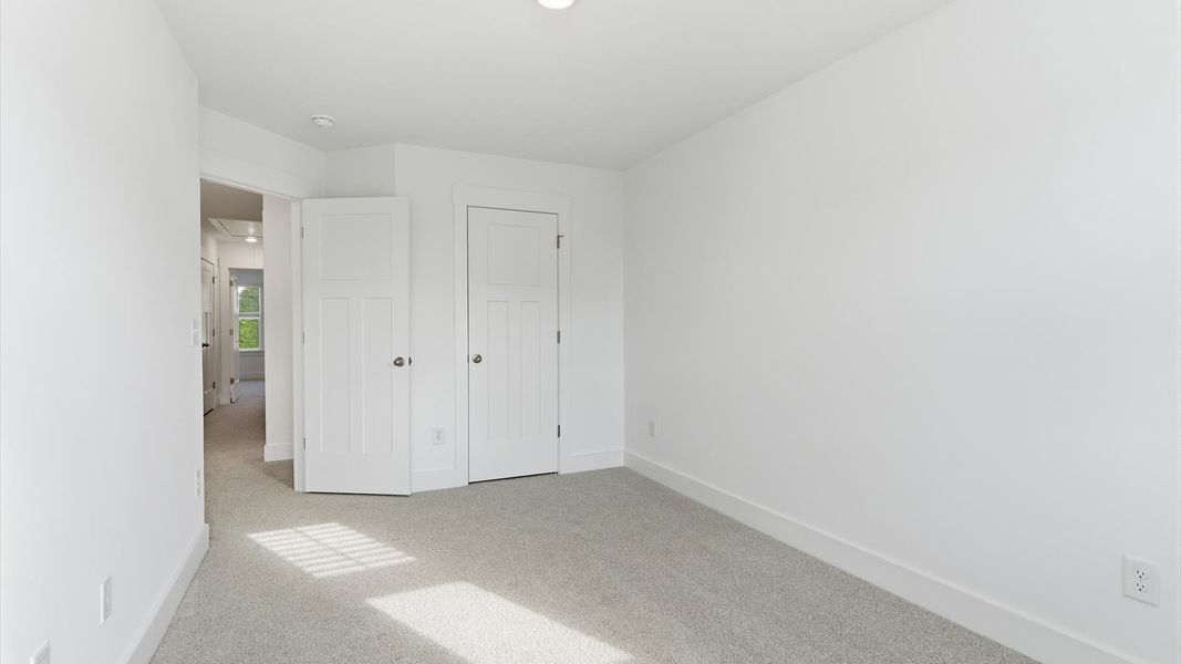 Tasteful bedroom with plush carpet, a walk-in closet, and large windows for abundant natural light at Silo Ridge