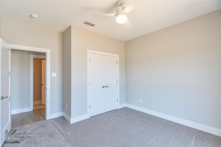Unfurnished bedroom featuring carpet, a closet, and ceiling fan