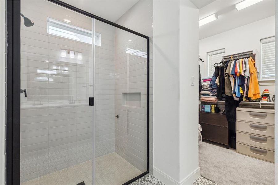 Full bath featuring baseboards, a spacious closet, and a stall shower Full bath featuring baseboards, a spacious closet, and a stall shower