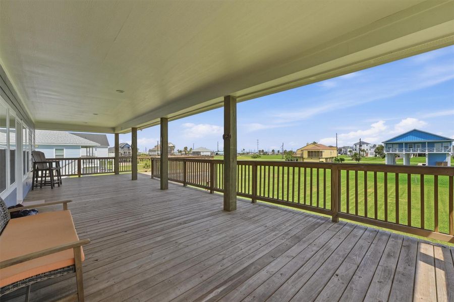Expansive covered deck with ample space for seating, offering serene views of the surrounding neighborhood and lush green lawns. Ideal for outdoor relaxation and entertaining. Expansive covered deck with ample space for seating, offering serene views of the surrounding neighborhood and lush green lawns. Ideal for outdoor relaxation and entertaining.