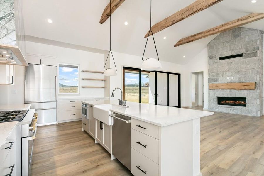 Kitchen featuring decorative light fixtures, high quality appliances, white cabinets, light wood-type flooring, and recessed lighting Kitchen featuring decorative light fixtures, high quality appliances, white cabinets, light wood-type flooring, and recessed lighting