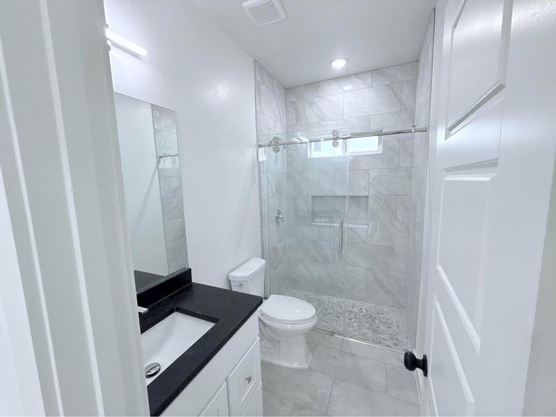 Bathroom with vanity, a stall shower, and light tile patterned flooring Bathroom with vanity, a stall shower, and light tile patterned flooring