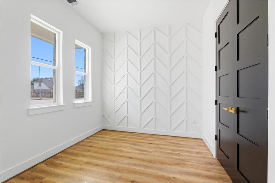 Inside, a dedicated office features stylish accent walls and a matching set of double doors to the right that open to a convenient closet, keeping the workspace organized and sleek.