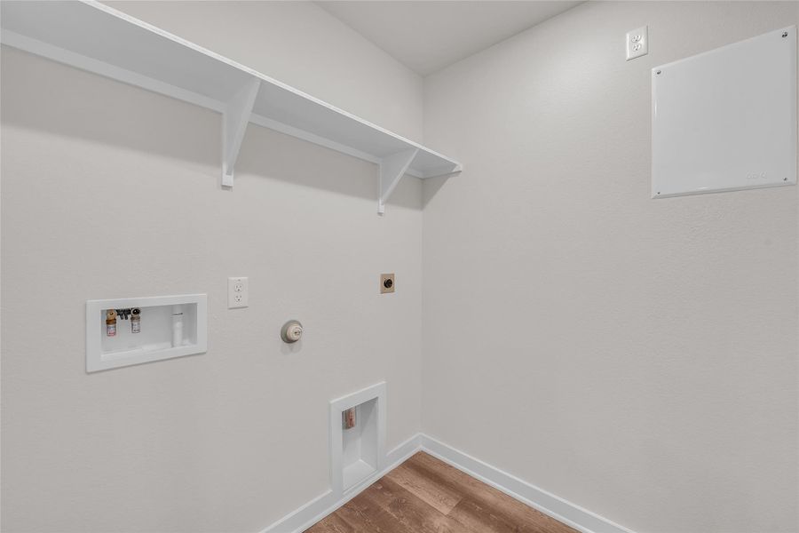 Laundry room featuring gas dryer hookup, wood finished floors, hookup for an electric dryer, and washer hookup Laundry room featuring gas dryer hookup, wood finished floors, hookup for an electric dryer, and washer hookup