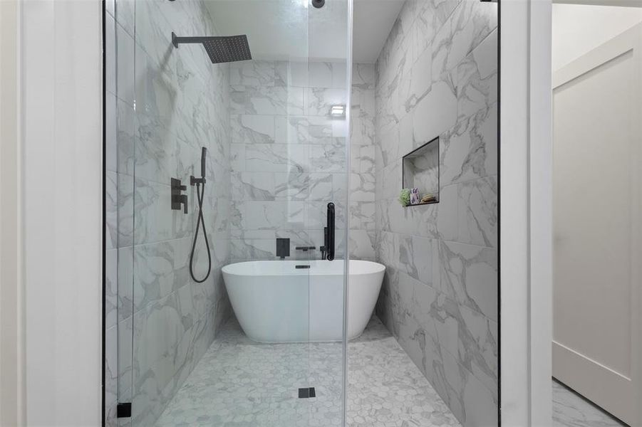 Full bath with tile walls, a marble finish shower, tile patterned floors, and a freestanding tub